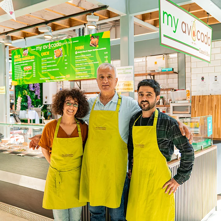 warrington-market-02 Three members of the my avocado team standing in front of the my avocado stall at Warrington Market.